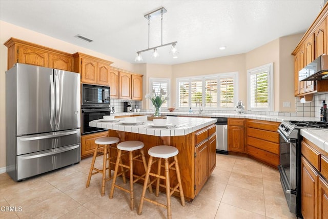 2210 Via Loma, Camarillo, CA 93012 - kitchen with black appliances, tile counters, backsplash, and a kitchen island