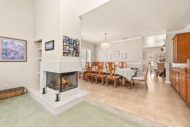 2210 Via Loma, Camarillo, CA 93012 - dining space featuring built in features, a tiled fireplace, crown molding, a chandelier, and light tile patterned floors