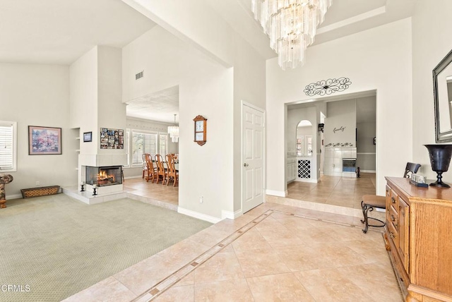 2210 Via Loma, Camarillo, CA 93012 - foyer featuring high vaulted ceiling, a chandelier, a multi sided fireplace, light tile patterned flooring, and arched walkways