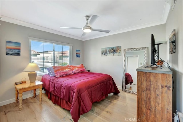 bedroom featuring a ceiling fan, baseboards, crown molding, and light wood-type flooring
