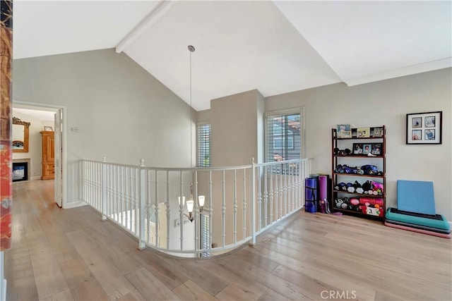 hall featuring high vaulted ceiling, beam ceiling, and wood finished floors