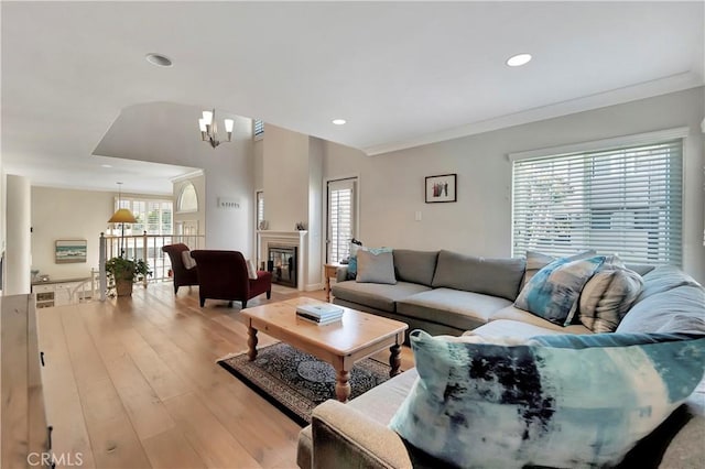 living area with recessed lighting, light wood-style floors, and crown molding