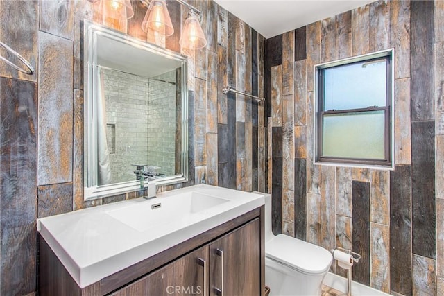bathroom with tile walls, toilet, and vanity