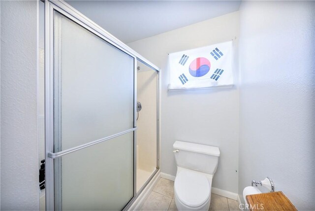 39240 Gunsmoke Ct, Palmdale, CA 93551 - bathroom with toilet, a shower stall, tile patterned floors, and baseboards