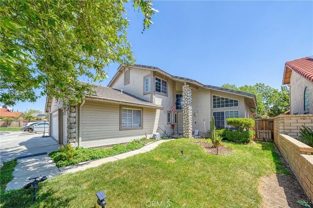 39240 Gunsmoke Ct, Palmdale, CA 93551 - view of front facade with fence, driveway, an attached garage, and a front lawn