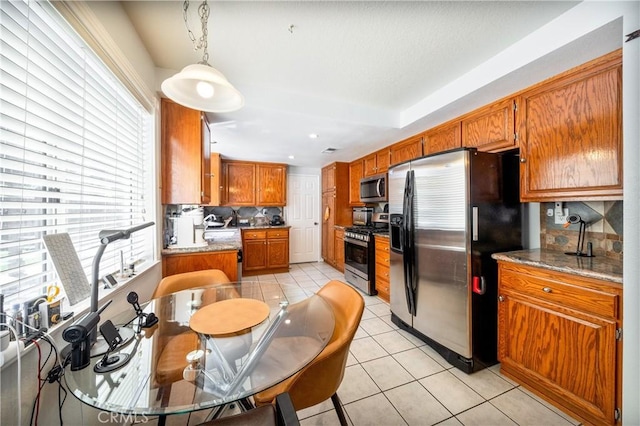 39240 Gunsmoke Ct, Palmdale, CA 93551 - kitchen featuring stainless steel appliances, a wealth of natural light, light tile patterned flooring, and decorative backsplash