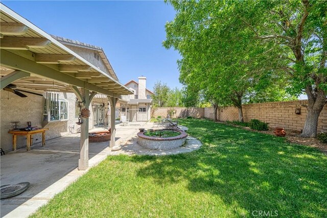 39240 Gunsmoke Ct, Palmdale, CA 93551 - view of yard featuring a patio, a fenced backyard, and an outdoor fire pit