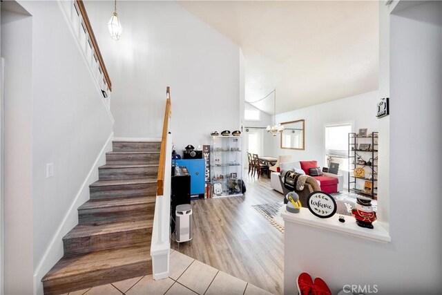 39240 Gunsmoke Ct, Palmdale, CA 93551 - stairway with tile patterned flooring, high vaulted ceiling, and a chandelier