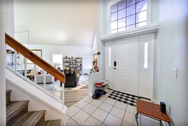 39240 Gunsmoke Ct, Palmdale, CA 93551 - entryway featuring light tile patterned flooring, baseboards, stairway, and a high ceiling