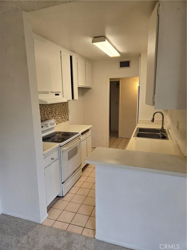 18307 Burbank Blvd Unit 7, Tarzana, CA 91356 - kitchen with electric range, under cabinet range hood, white cabinetry, backsplash, and light countertops