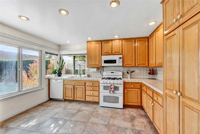 kitchen with white appliances, tile countertops, baseboards, backsplash, and recessed lighting