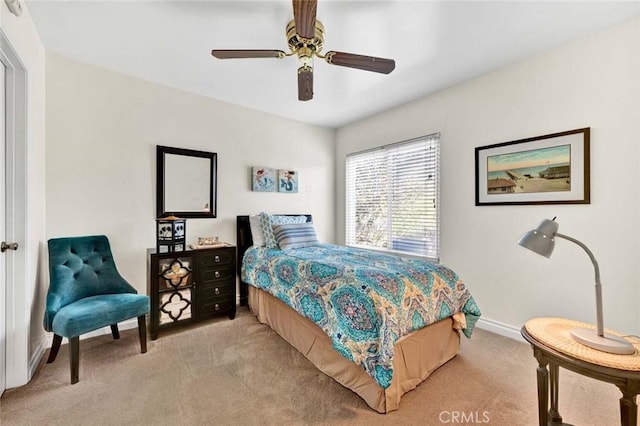 bedroom with light colored carpet, baseboards, and a ceiling fan