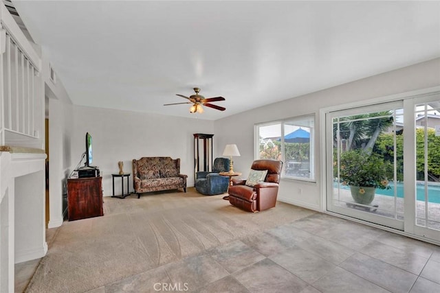 sitting room featuring light colored carpet, a ceiling fan, and baseboards