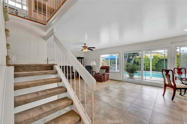 stairway with tile patterned flooring and ceiling fan