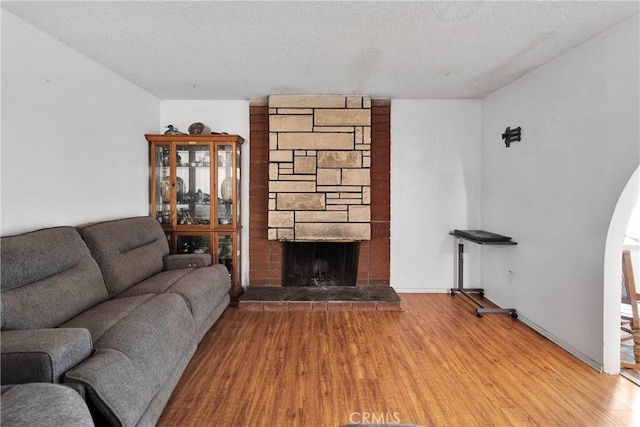 1844 Alston Ave, Colton, CA 92324 - living room with arched walkways, a textured ceiling, wood finished floors, and a fireplace