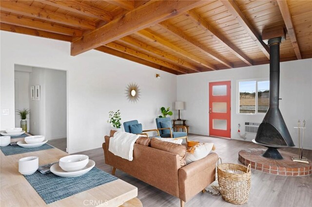 52024 Nehlsen Rd, Johnson Valley, CA 92285 - living area featuring wood finished floors, a wood stove, an AC wall unit, wooden ceiling, and lofted ceiling with beams