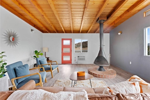 52024 Nehlsen Rd, Johnson Valley, CA 92285 - living area with wood finished floors, a wood stove, an AC wall unit, vaulted ceiling with beams, and wood ceiling