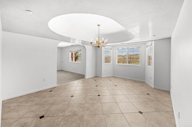 unfurnished room featuring tile patterned flooring, baseboards, arched walkways, and a chandelier