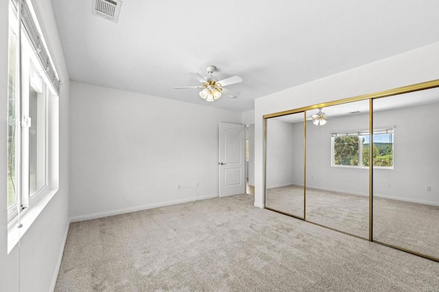 unfurnished bedroom featuring baseboards, visible vents, a ceiling fan, a closet, and carpet floors