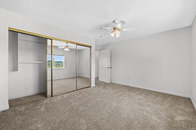 unfurnished bedroom featuring carpet floors, a closet, a ceiling fan, and baseboards
