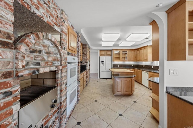 kitchen featuring a center island, wooden counters, white appliances, glass insert cabinets, and a fireplace