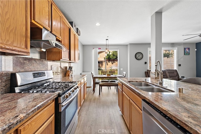 5332 Trailhawk Ave, Fontana, CA 92336 - kitchen with appliances with stainless steel finishes, a sink, light wood-style flooring, tasteful backsplash, and under cabinet range hood