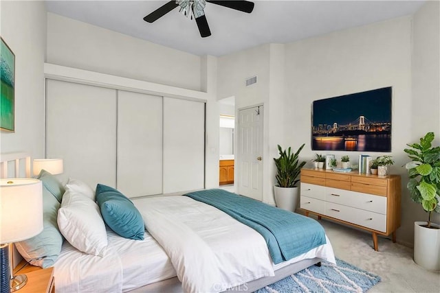 bedroom featuring a closet, a ceiling fan, light colored carpet, and visible vents