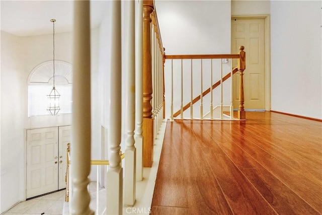 entrance foyer with stairs, wood finished floors, and a notable chandelier