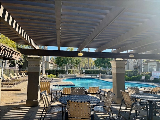 community pool with a pergola, fence, and a patio
