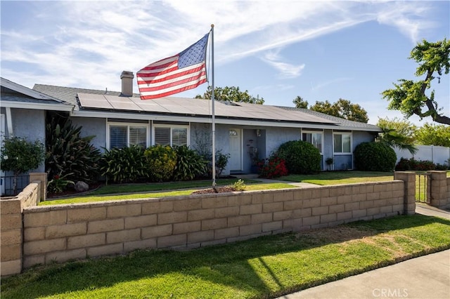1709 S Helen Ave, Ontario, CA 91762 - view of front of house featuring a chimney, fence, solar panels, stucco siding, and a front yard