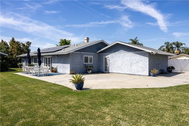 1709 S Helen Ave, Ontario, CA 91762 - view of front of property with a patio area, a front lawn, roof mounted solar panels, fence, and stucco siding