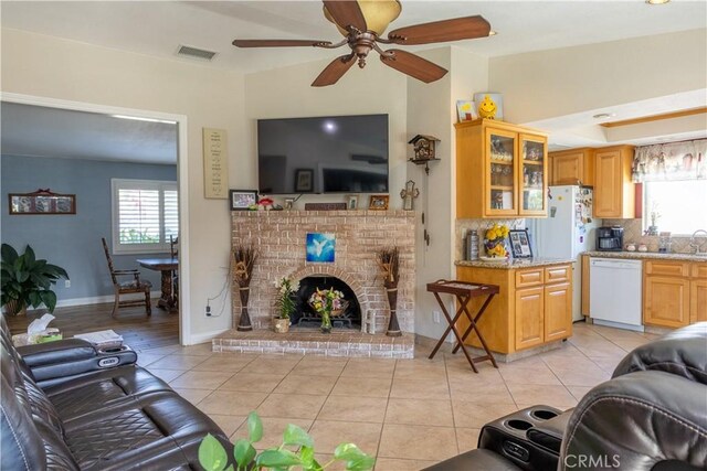 1709 S Helen Ave, Ontario, CA 91762 - living room with light tile patterned flooring, baseboards, visible vents, ceiling fan, and a fireplace