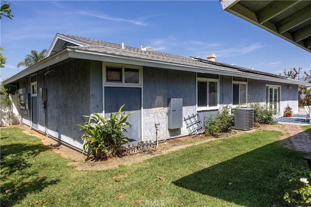 1709 S Helen Ave, Ontario, CA 91762 - view of side of home featuring central air condition unit, a lawn, a chimney, and stucco siding