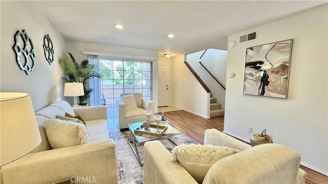 living room with recessed lighting, stairs, visible vents, baseboards, and wood finished floors