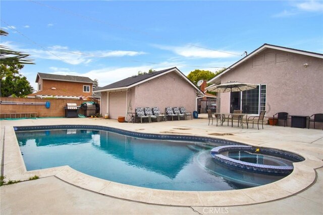 view of pool featuring a patio, a pool with connected hot tub, and fence