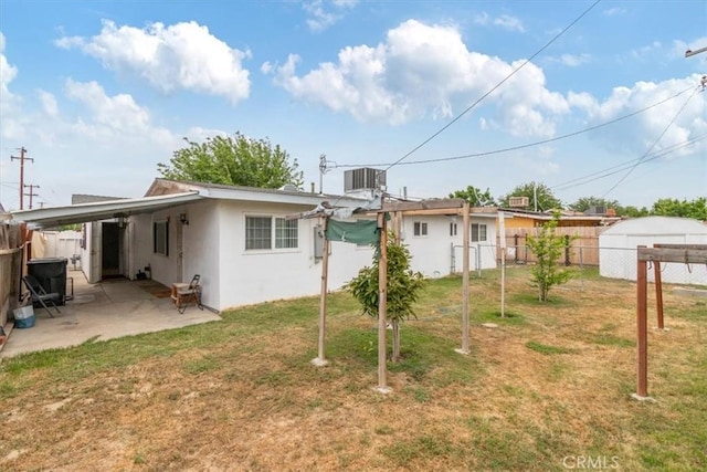 rear view of property with a fenced backyard, cooling unit, a patio area, a lawn, and stucco siding