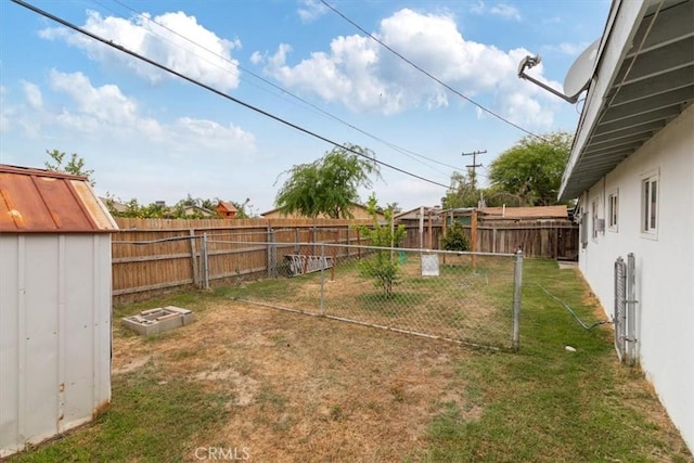 view of yard featuring a storage shed, a fenced backyard, and an outdoor structure