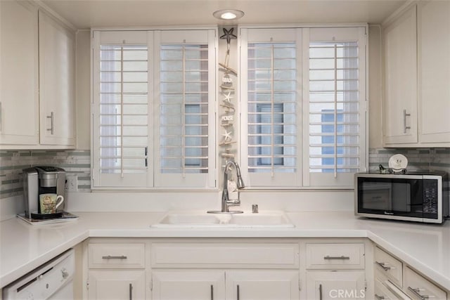 15 Via Castilla Unit T, Laguna Woods, CA 92637 - kitchen featuring stainless steel microwave, a sink, white dishwasher, white cabinetry, and decorative backsplash