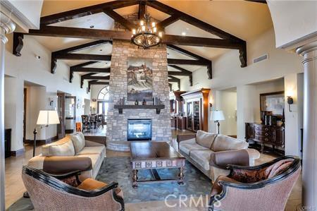 15 Via Castilla Unit T, Laguna Woods, CA 92637 - living area featuring a fireplace, high vaulted ceiling, beam ceiling, a chandelier, and ornate columns