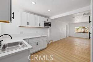 35328 80th St, Littlerock, CA 93543 - kitchen with stainless steel microwave, a sink, light countertops, light wood-style flooring, and recessed lighting