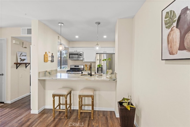14133 Bayside Dr, Norwalk, CA 90650 - kitchen with appliances with stainless steel finishes, a sink, dark wood-type flooring, a breakfast bar area, and recessed lighting