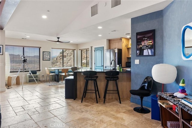57093 Monticello Ct, Yucca Valley, CA 92284 - kitchen featuring recessed lighting, a ceiling fan, freestanding refrigerator, stone tile flooring, and a peninsula