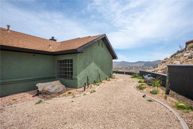 57093 Monticello Ct, Yucca Valley, CA 92284 - view of side of property featuring stucco siding and a mountain view