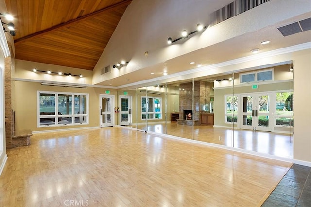 exercise room with high vaulted ceiling, wood ceiling, visible vents, and baseboards