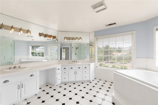 bathroom featuring a shower stall, a garden tub, vanity, and visible vents