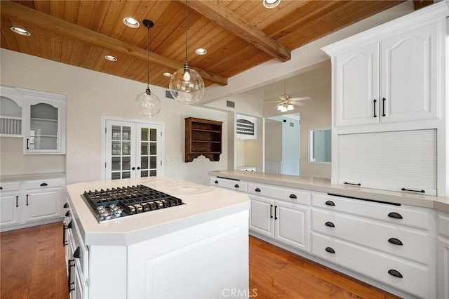 kitchen featuring stainless steel gas cooktop, french doors, light countertops, wooden ceiling, and beam ceiling