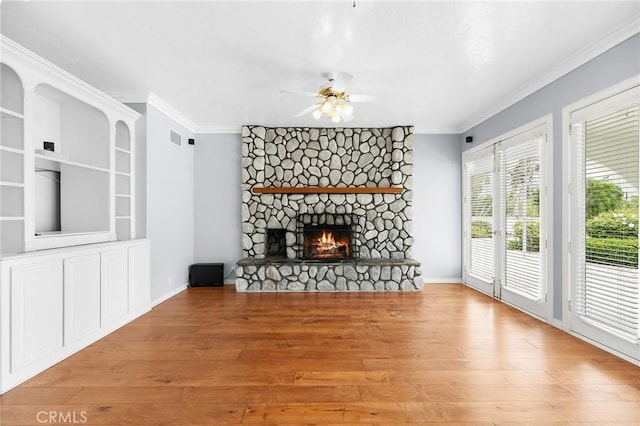 unfurnished living room with visible vents, a ceiling fan, wood finished floors, and crown molding