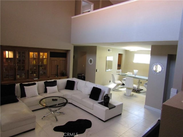 living room featuring a towering ceiling and visible vents
