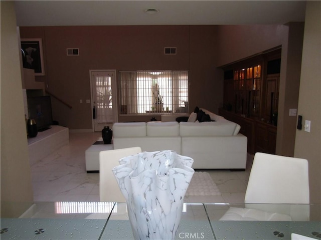 living area with visible vents and marble finish floor