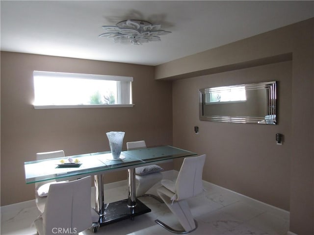 office area with a wealth of natural light, marble finish floor, and baseboards